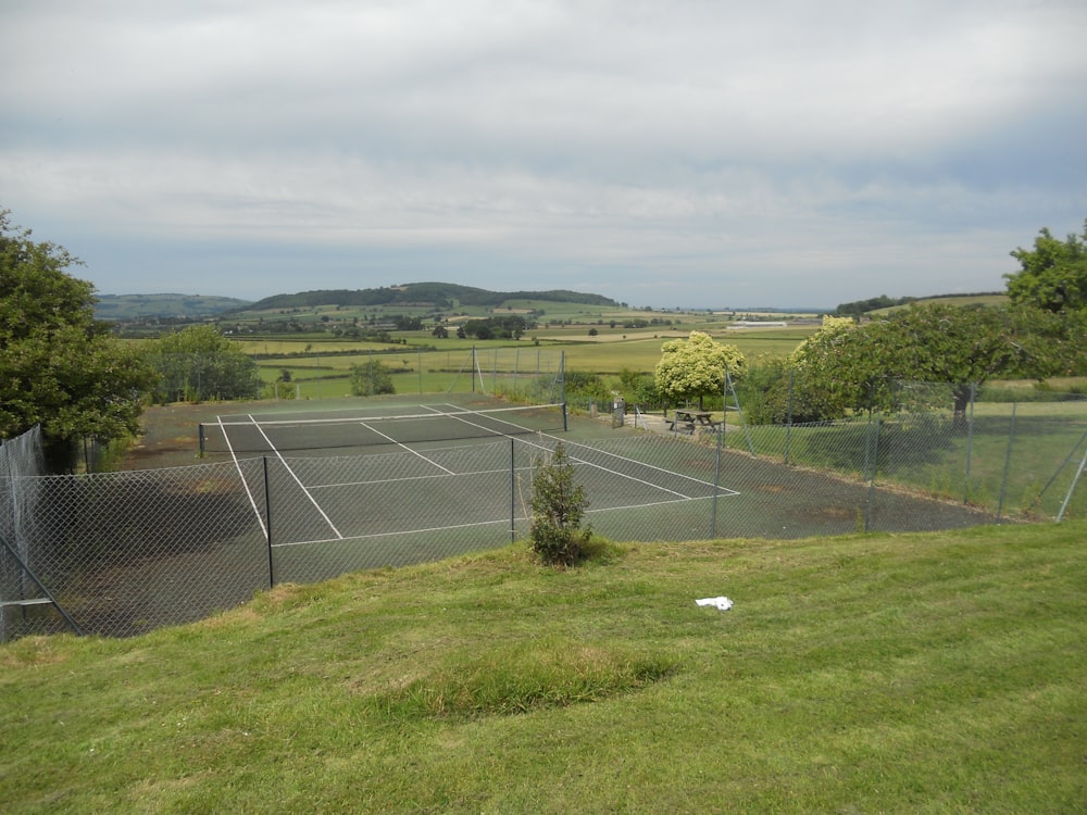 a view of a tennis court from the top of a hill