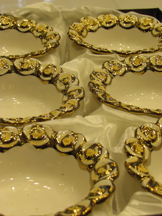 Elegant ceramic bowls with intricate blue and gold patterns arranged on a cream linen cloth