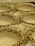 A collection of ornately designed ceramic or porcelain bowls with an elegant floral pattern featuring gold and white colors. The bowls are resting on a soft, white fabric, enhancing their luxurious appearance.