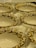 A collection of ornately designed ceramic or porcelain bowls with an elegant floral pattern featuring gold and white colors. The bowls are resting on a soft, white fabric, enhancing their luxurious appearance.