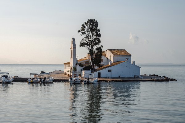 A small white house sitting on top of a pier — Corfu, Greece