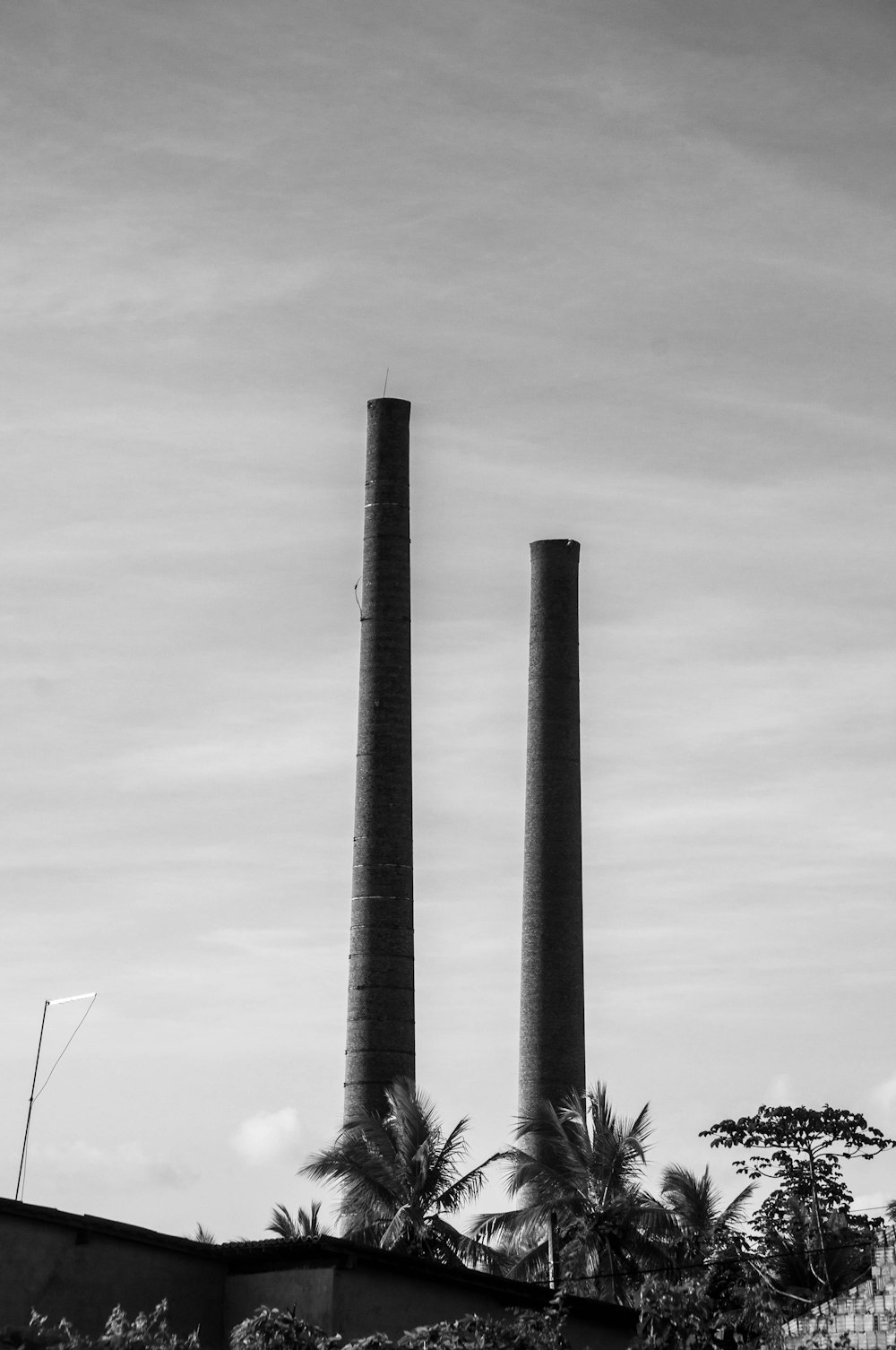 a black and white photo of two smoke stacks