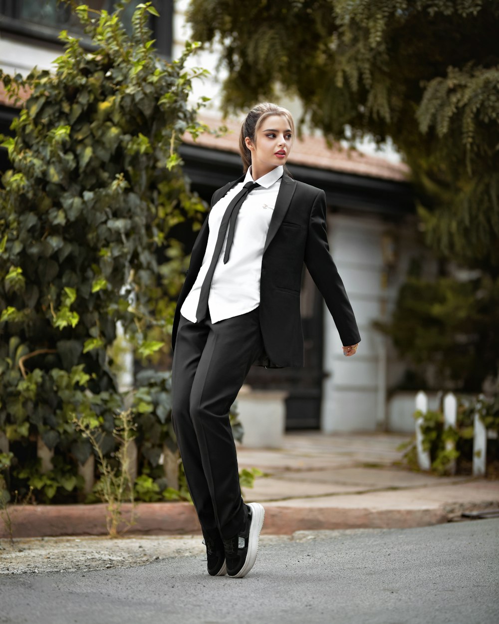 a woman in a suit is walking down the street