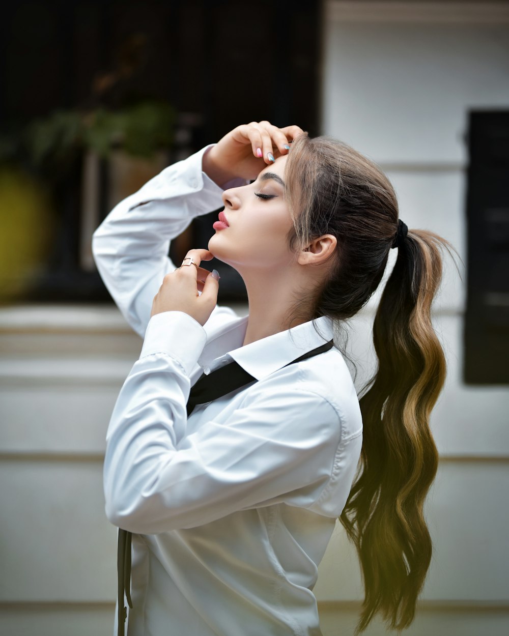 a woman with long hair wearing a white shirt and black tie