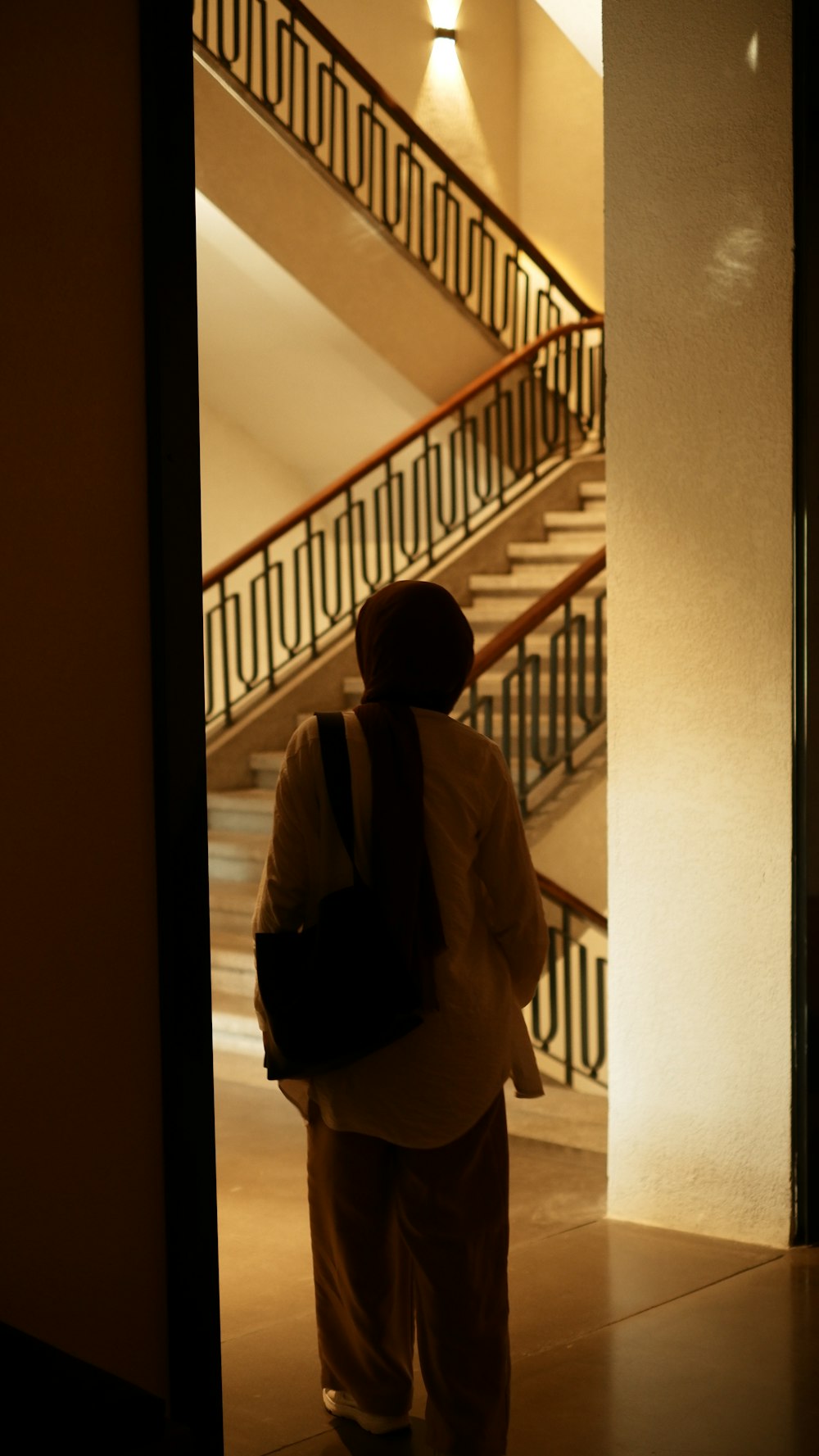 a man with a backpack walking down a hallway