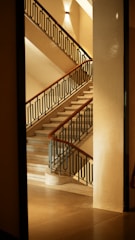 Modern steel railing installed on a staircase with warm lighting.