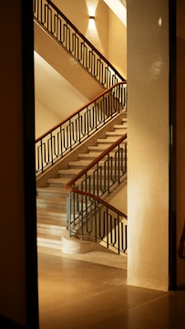 Modern steel railing installed on a staircase with warm lighting.