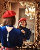 A smiling woman trying on a colorful scarf in front of a mirror