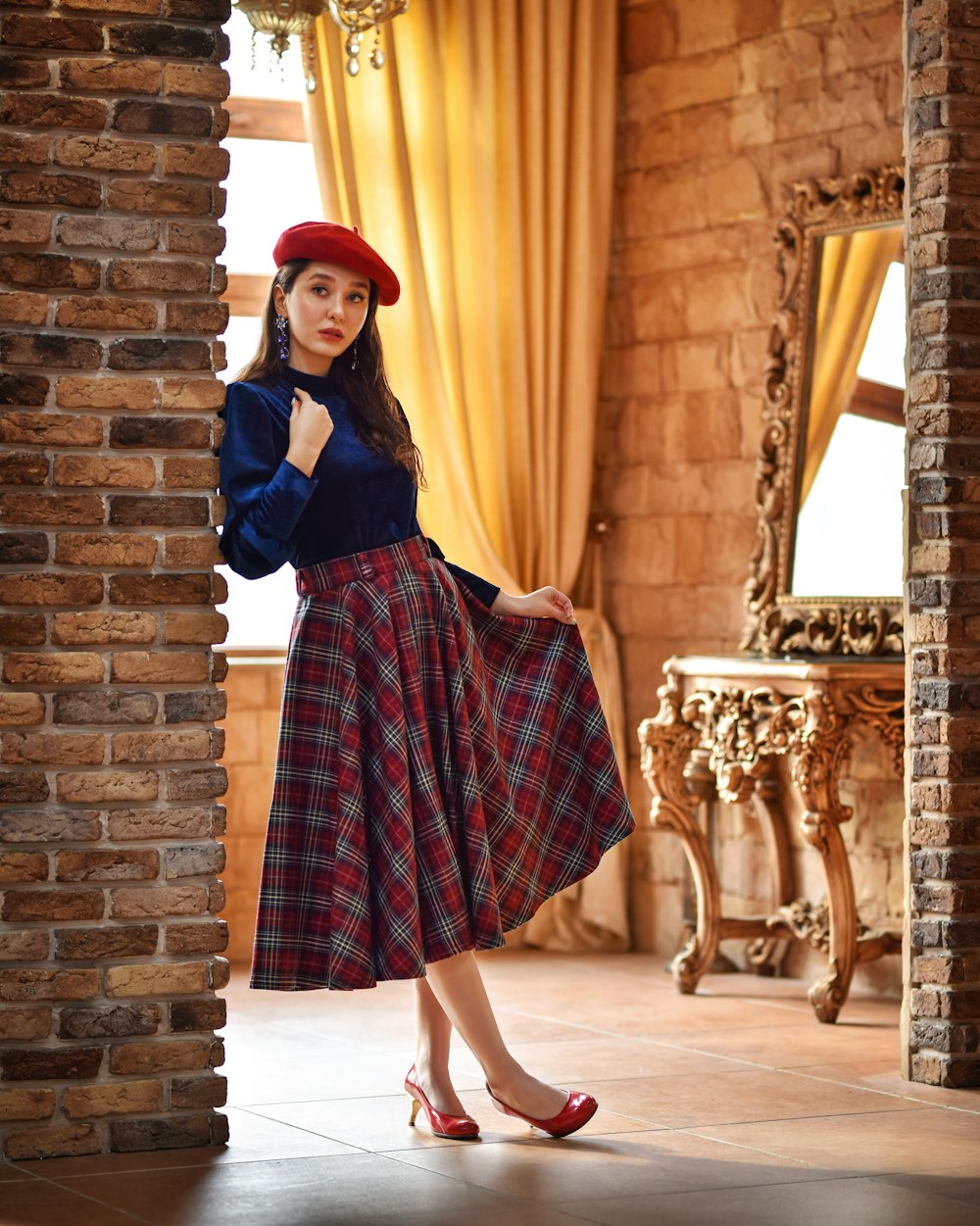 a woman in a blue top and a red plaid skirt