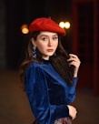 a woman in a blue dress and a red hat