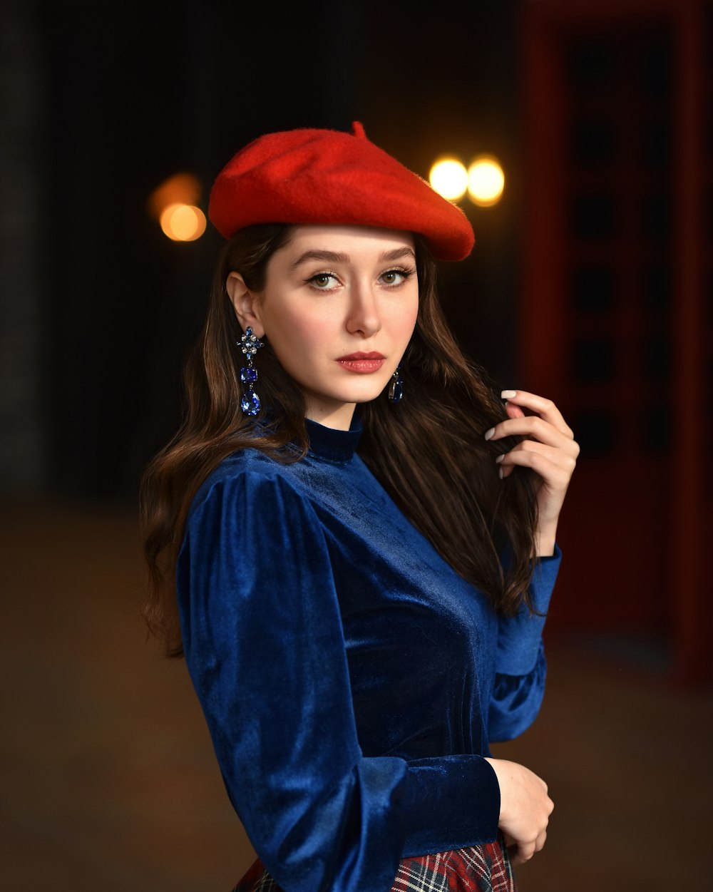 a woman in a blue dress and a red hat