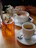 A group of friends laughing around a wooden table with steaming coffee cups.