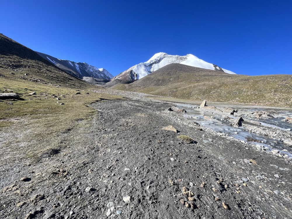 a dirt road with a mountain in the background