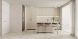 Wide shot of a modern kitchen island with integrated appliances and minimalist decor in soft beige hues.
