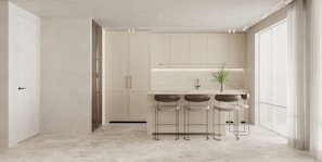 A contemporary open-plan kitchen with a large island and bar stools.