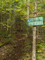 Local hiking trail marked by rustic wooden signs and vibrant autumn foliage.