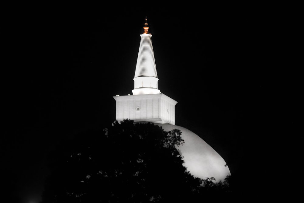 a church steeple lit up at night