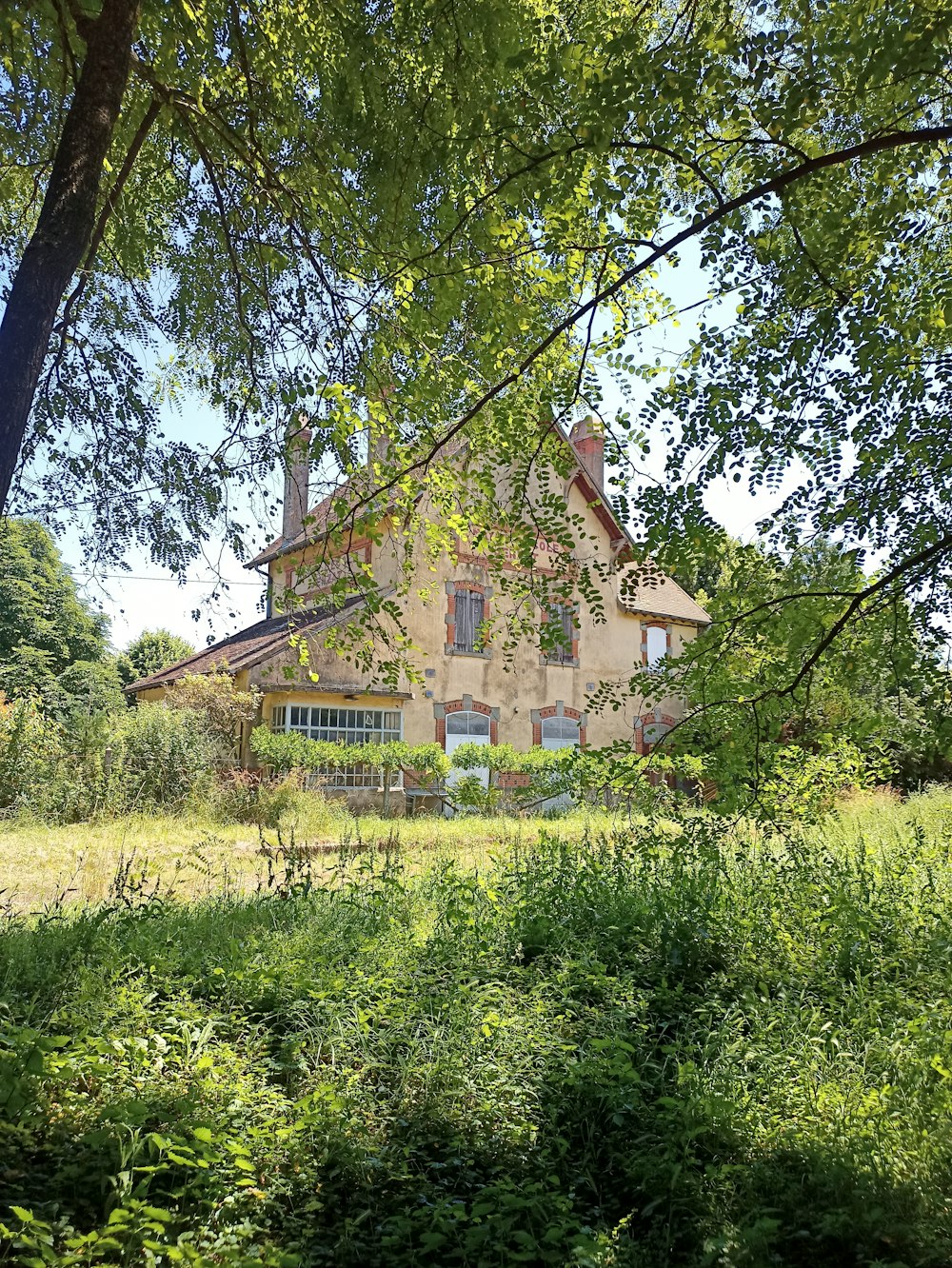 a large house sitting in the middle of a lush green field