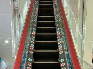 A senior smiling as they safely ascend stairs using elevita's escalator system.