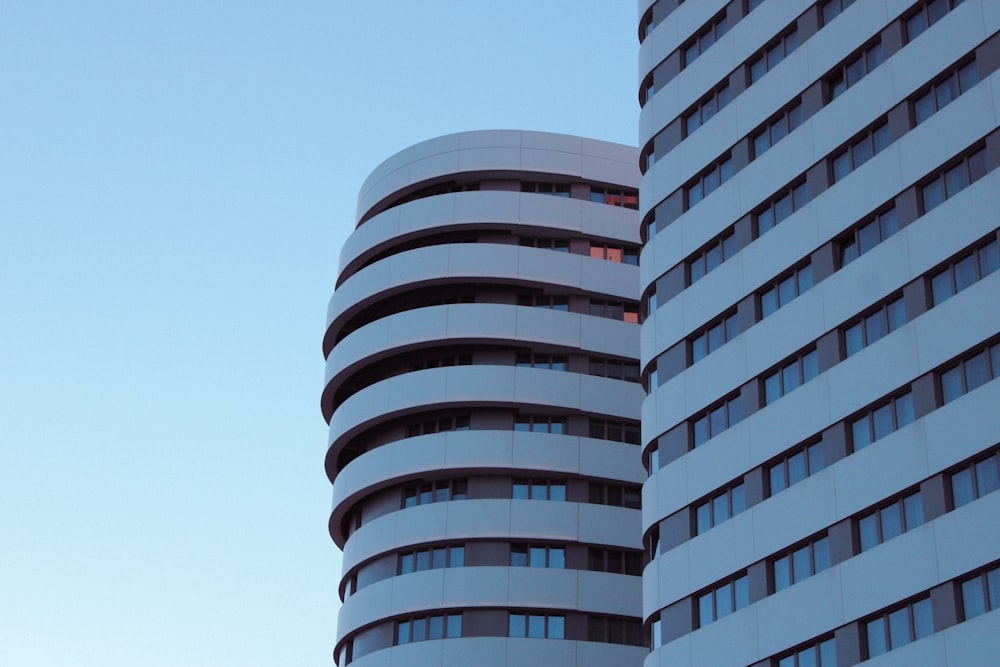 two tall buildings with a sky in the background