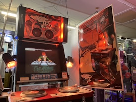 A retro-style arcade machine featuring DJ-themed graphics with turntables and speakers. It includes vibrant posters with graffiti art and bold designs, surrounded by soft, ambient lighting.