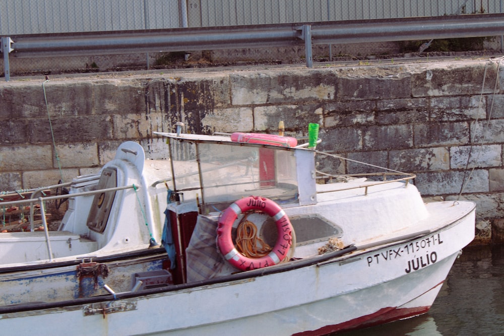 a white boat with a life preserver in the water