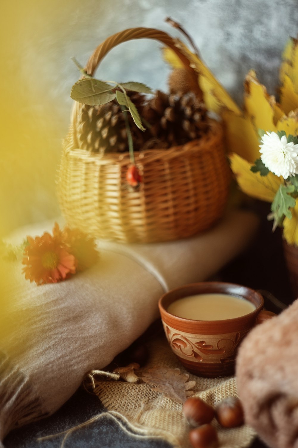 a basket filled with pine cones next to a cup of coffee