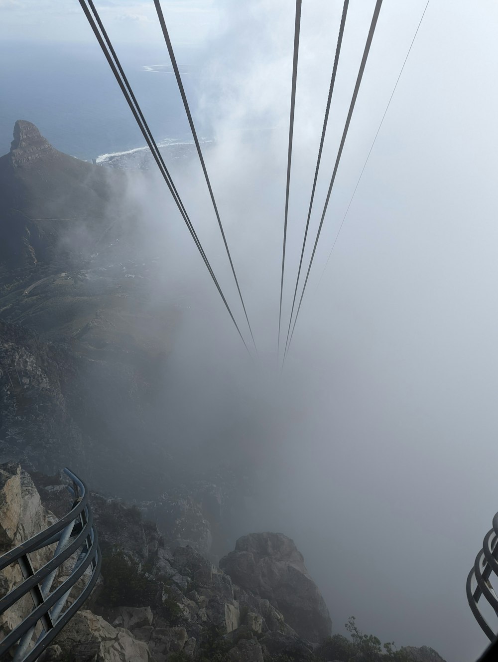 a cable car going over a mountain in the fog