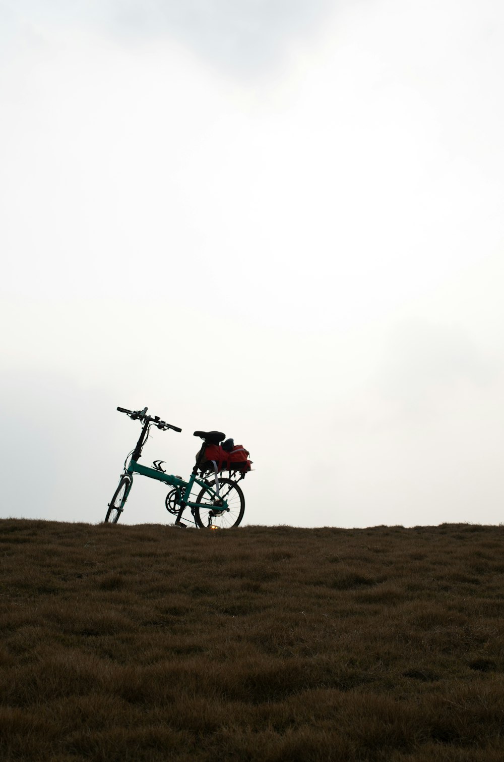 a bike parked on top of a dry grass field