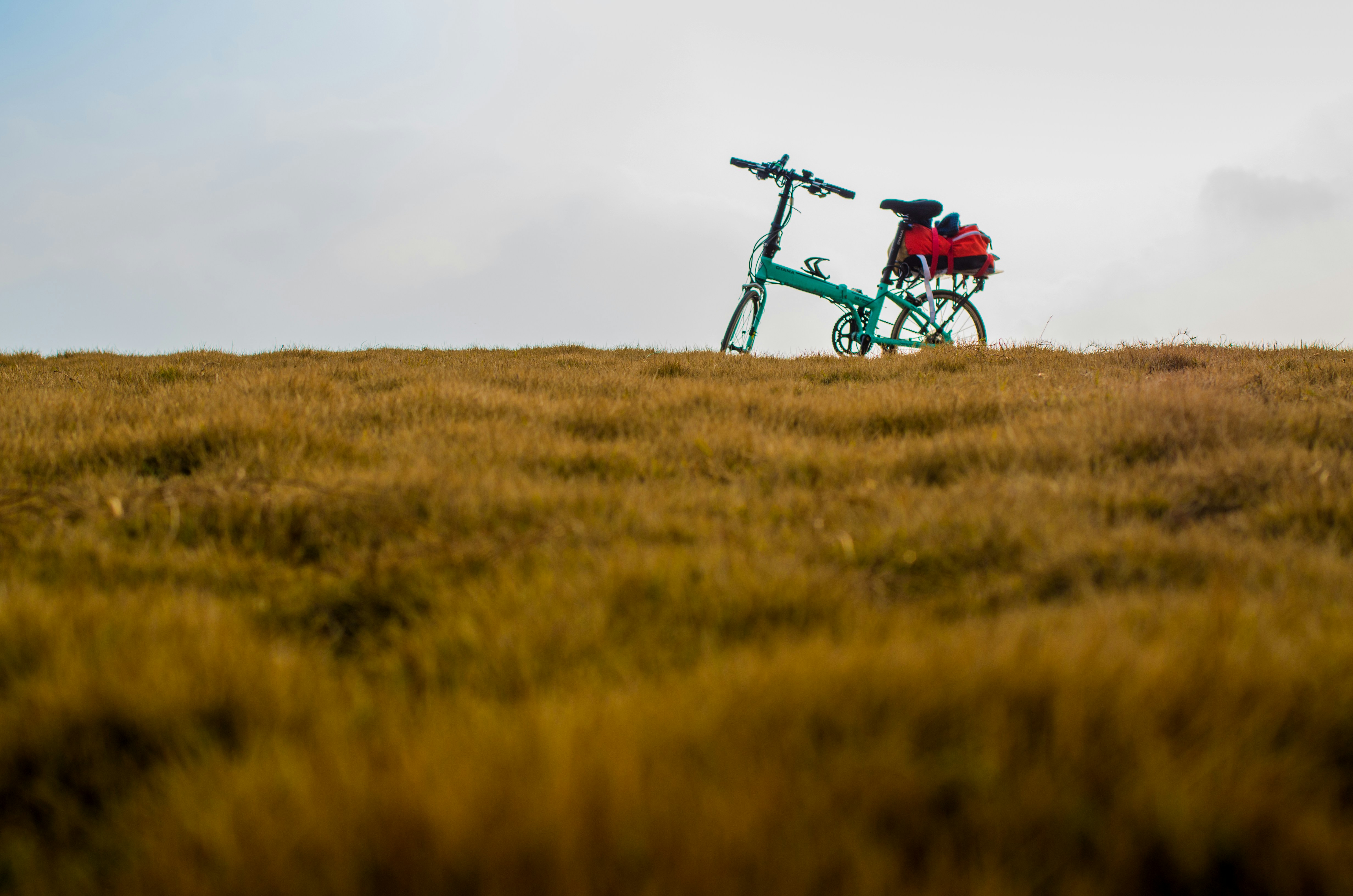 a bike parked on top of a grass covered hill
