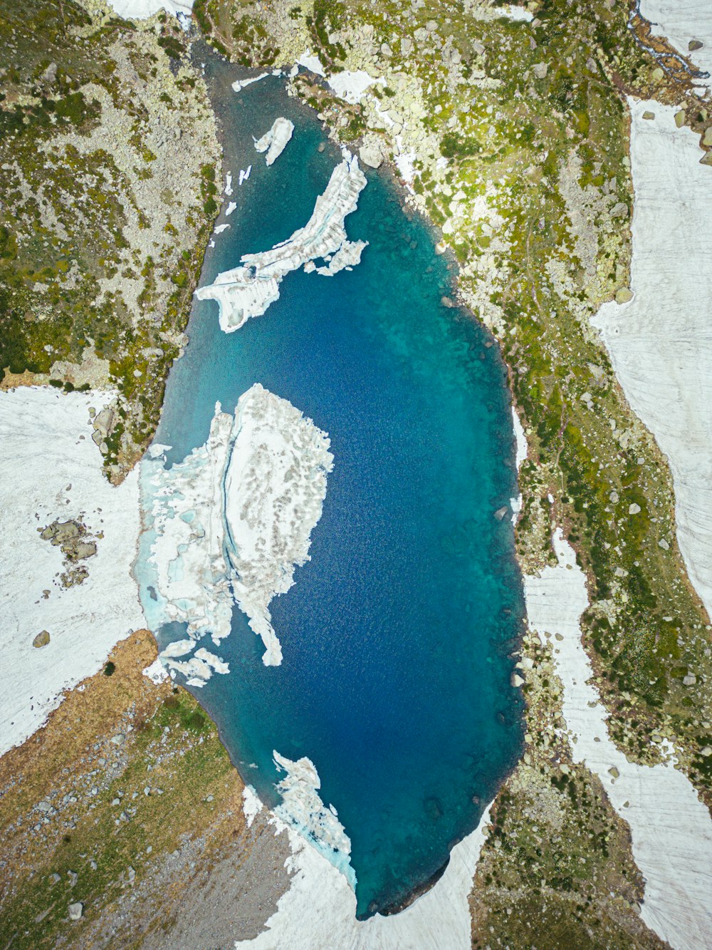 a large body of water surrounded by snow covered mountains