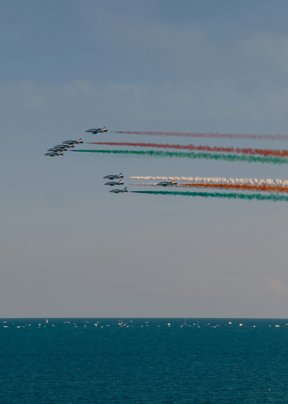 a group of fighter jets flying over the ocean