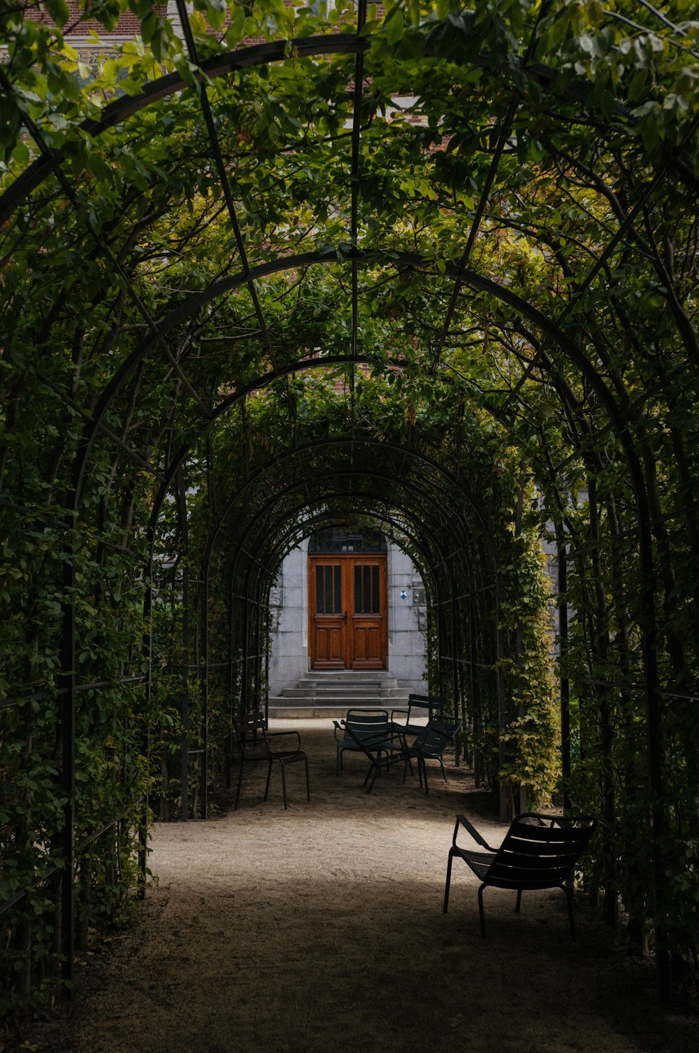 an archway with benches and a red door