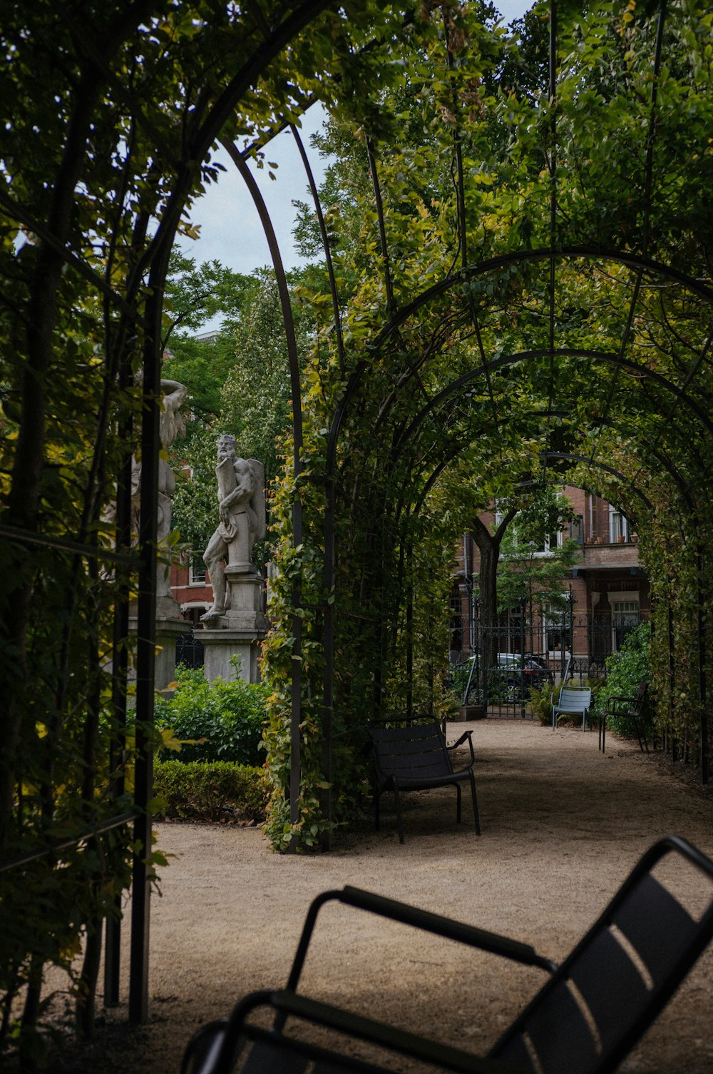 a bench sitting under an archway in a park