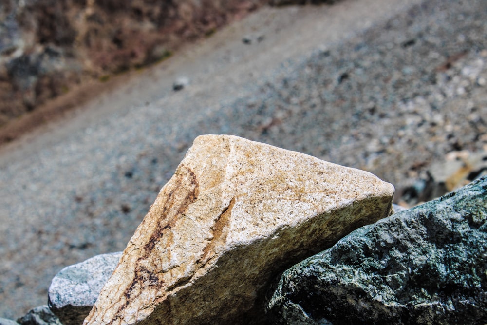 a rock sitting on the side of a road