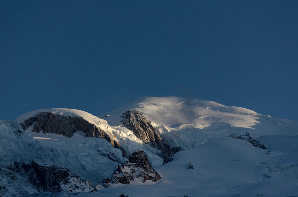 a mountain covered in snow under a blue sky