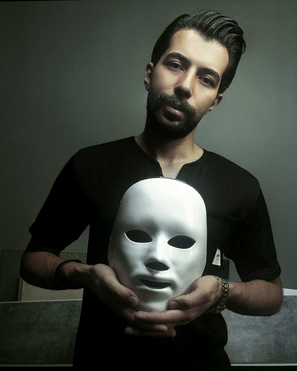 un homme tenant un masque blanc dans ses mains