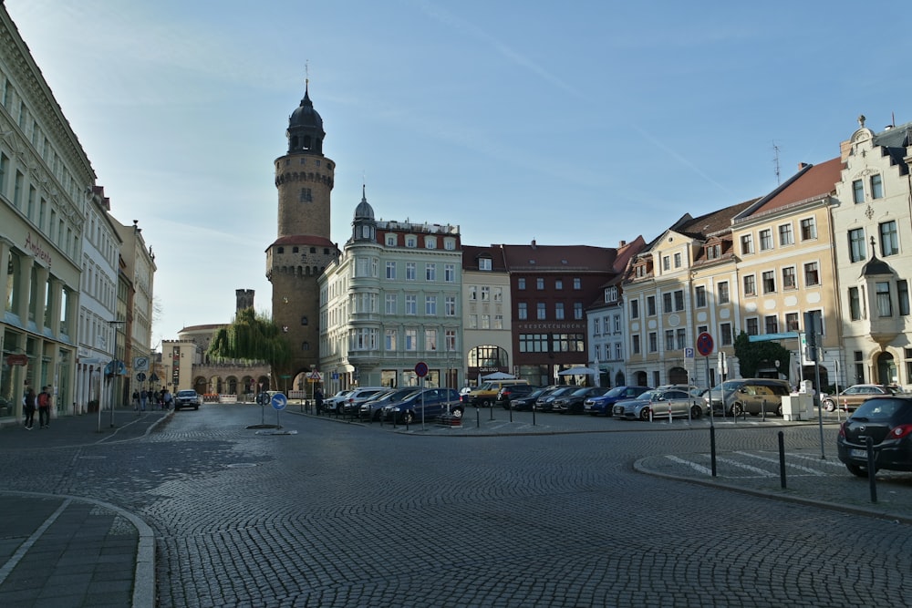 Una calle de la ciudad con una torre del reloj al fondo