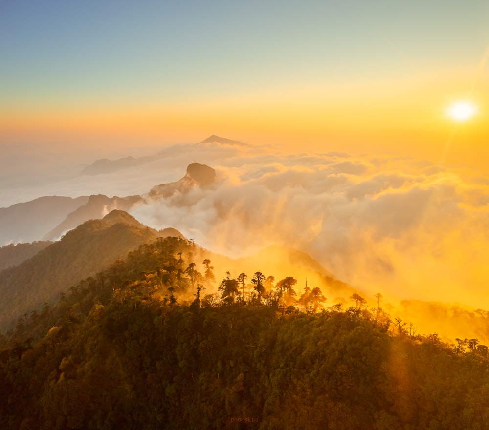 the sun is setting over a mountain range