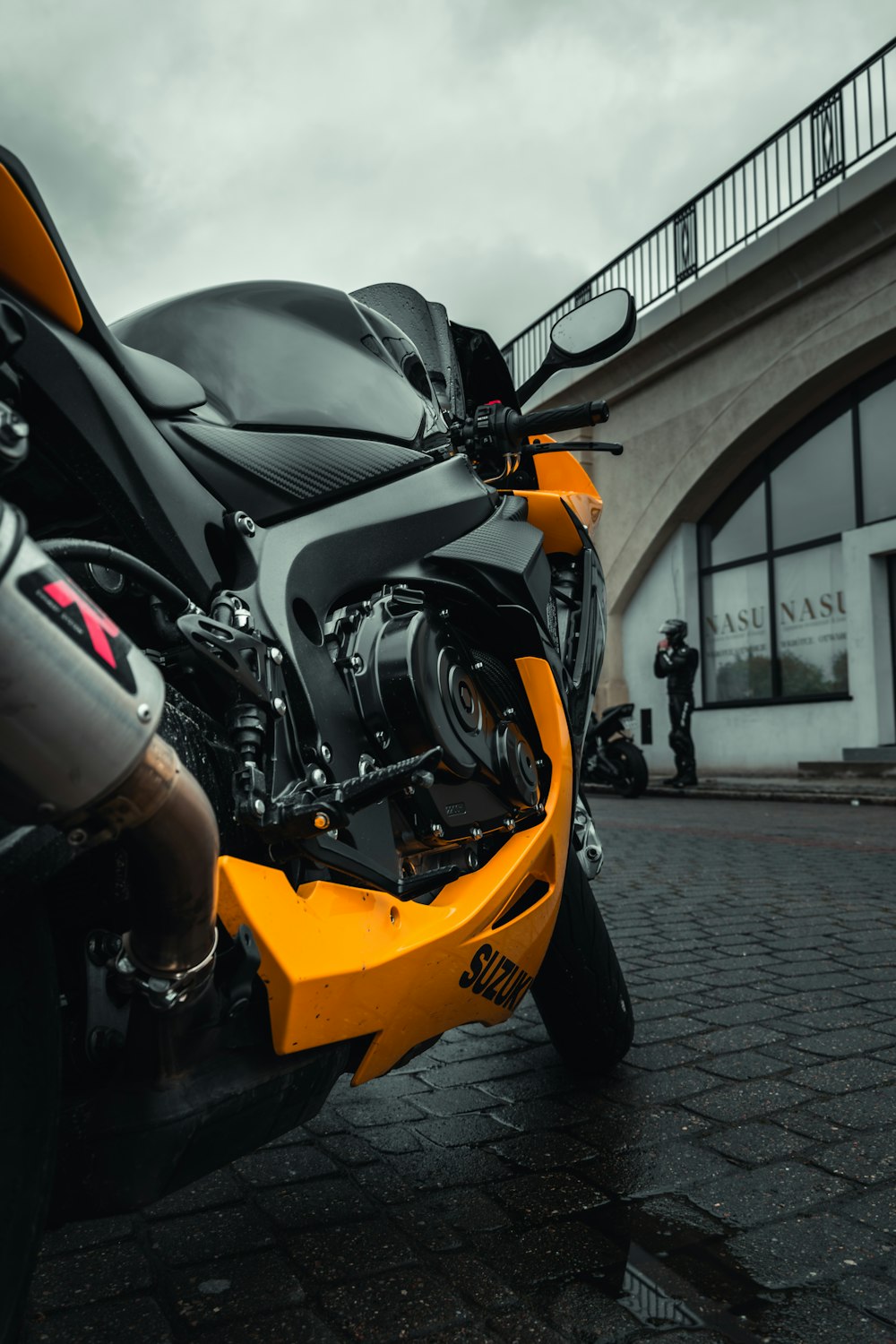 a yellow and black motorcycle parked in front of a building