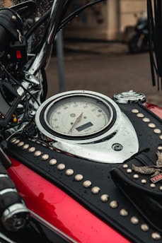 A close-up of a sleek motorcycle dashboard with the city blurred in the background.