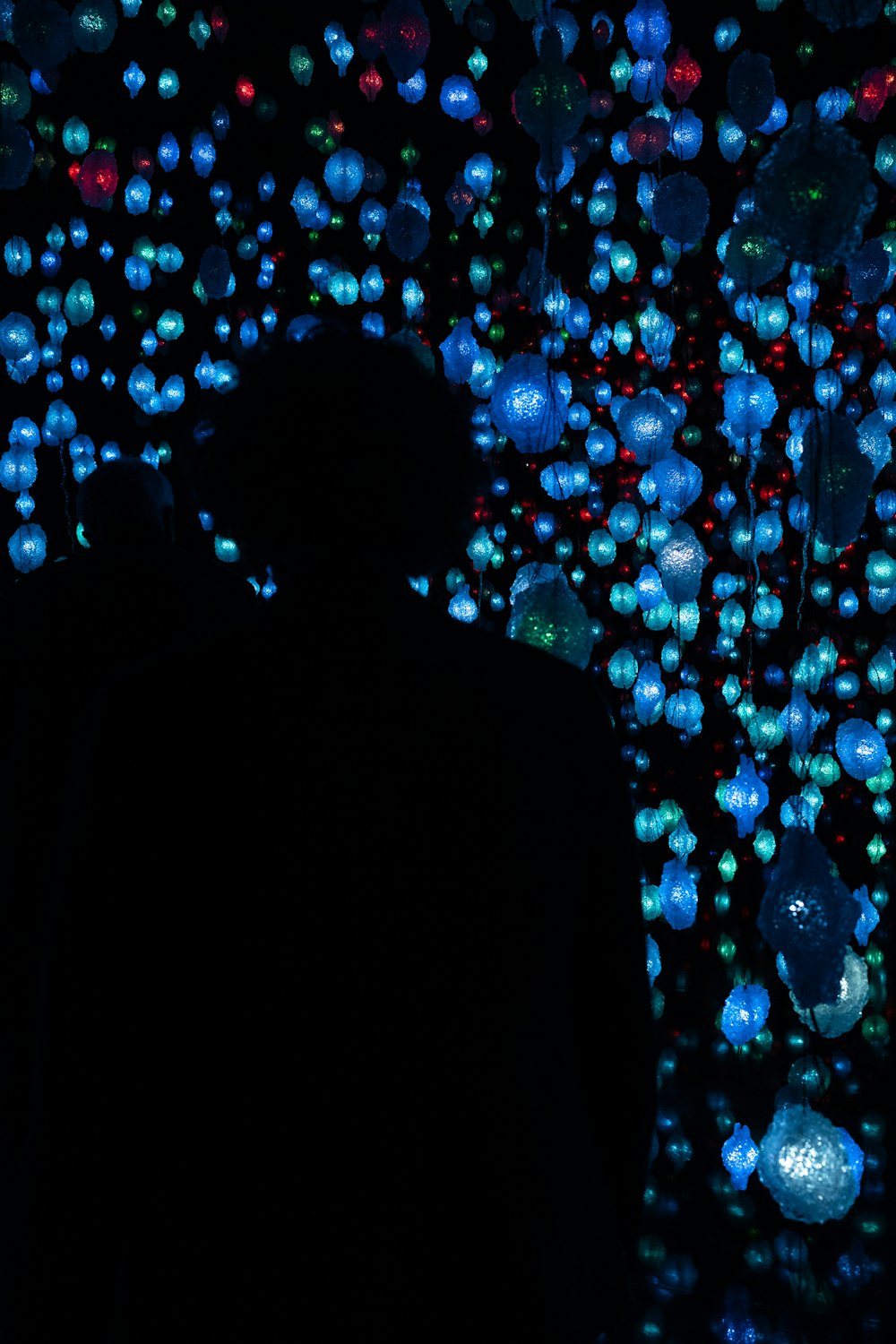 a man standing in front of a wall of balloons