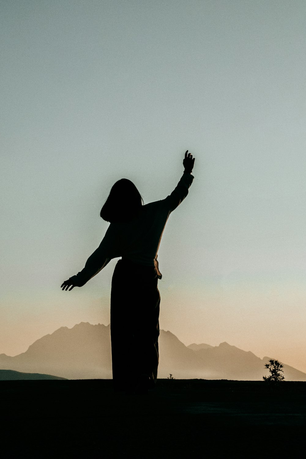 a silhouette of a person with their arms outstretched