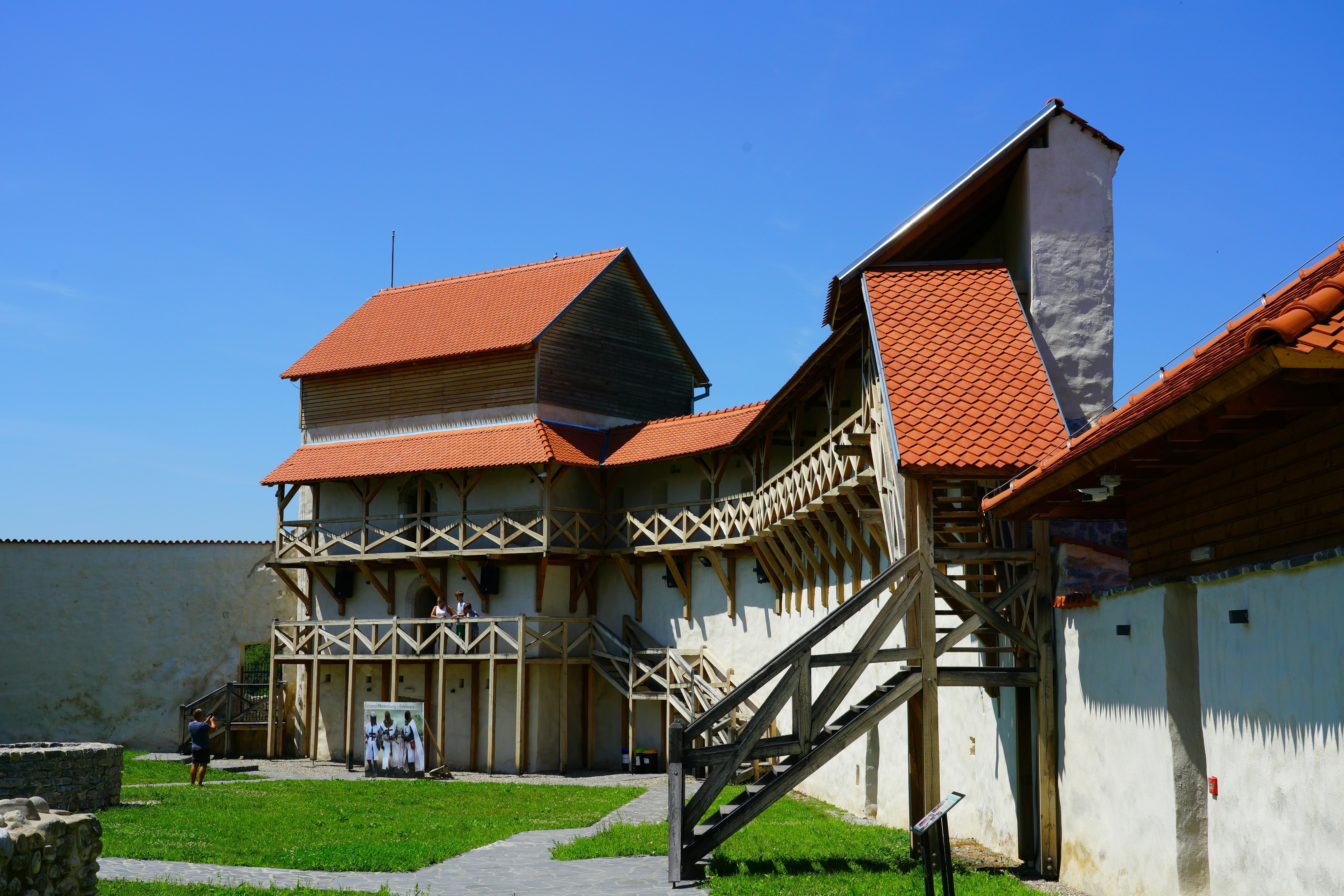 a building with a red roof and a wooden fence