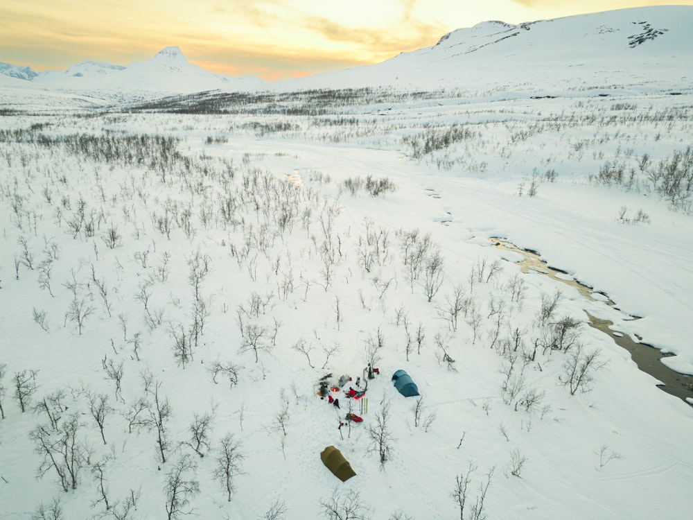 a group of people walking across a snow covered field