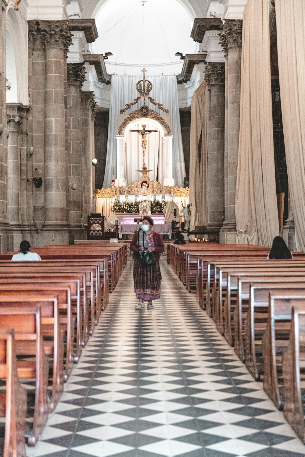 a woman walking down the aisle of a church