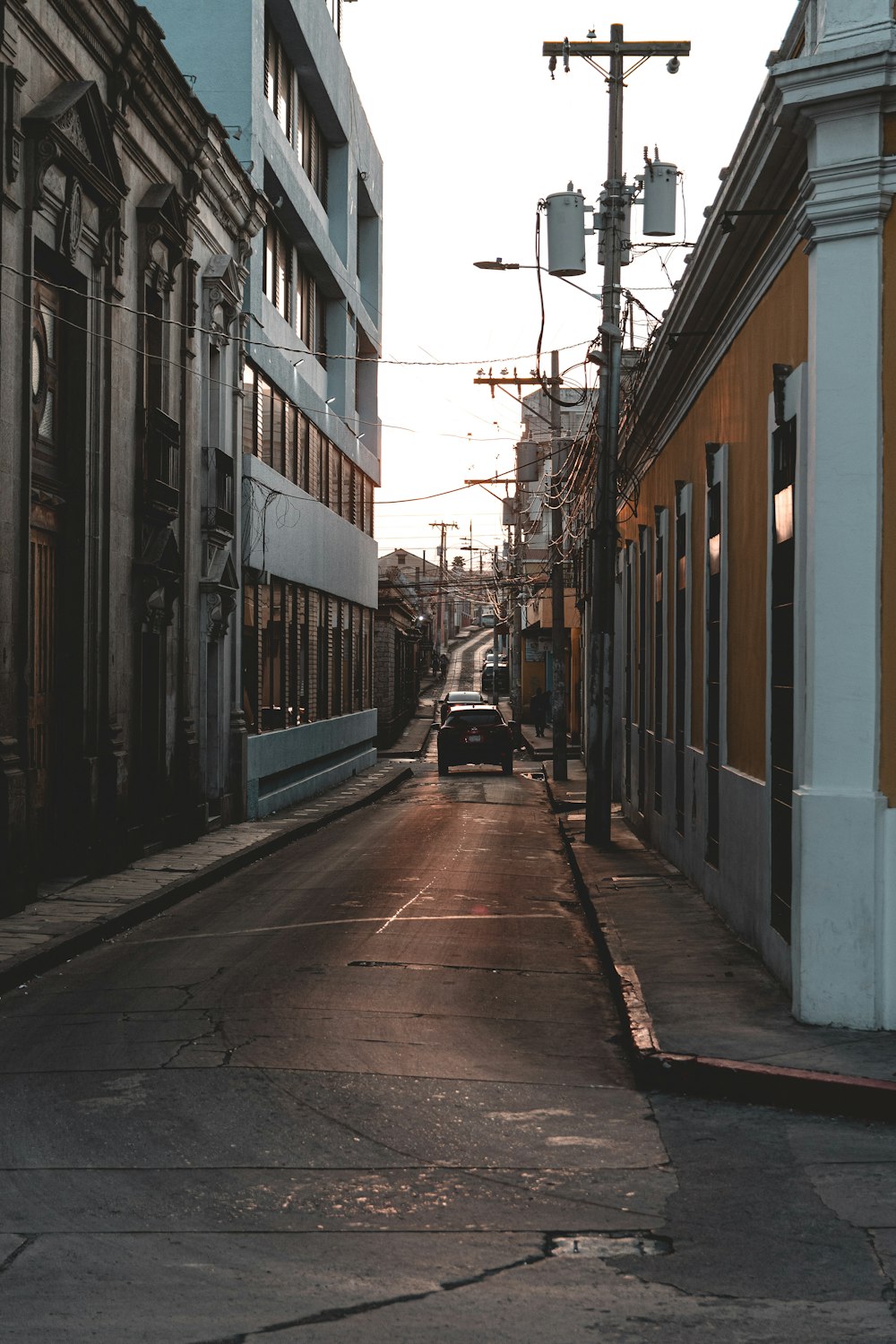 a car driving down a street next to tall buildings