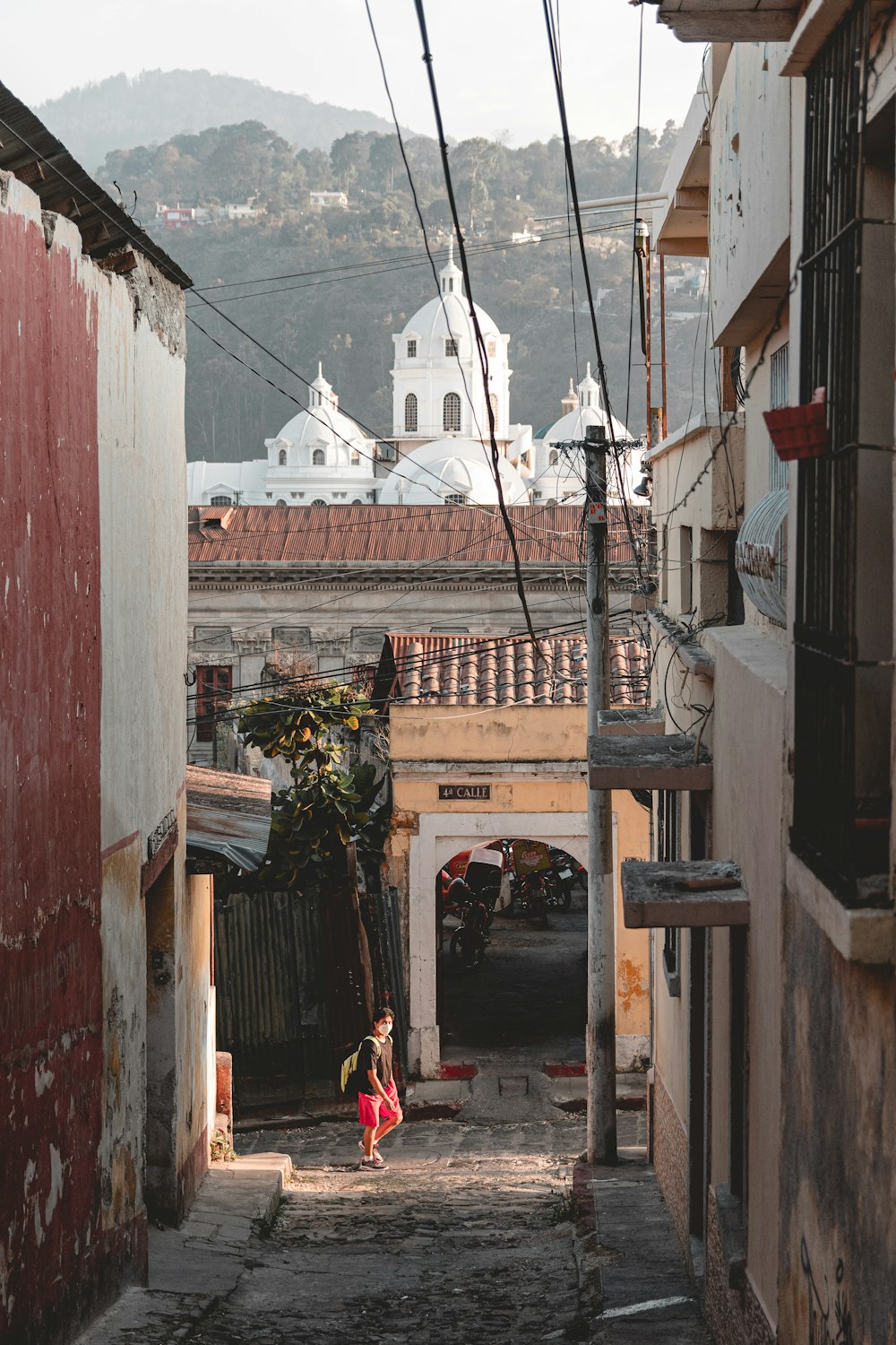 a narrow alley way with a person walking down it