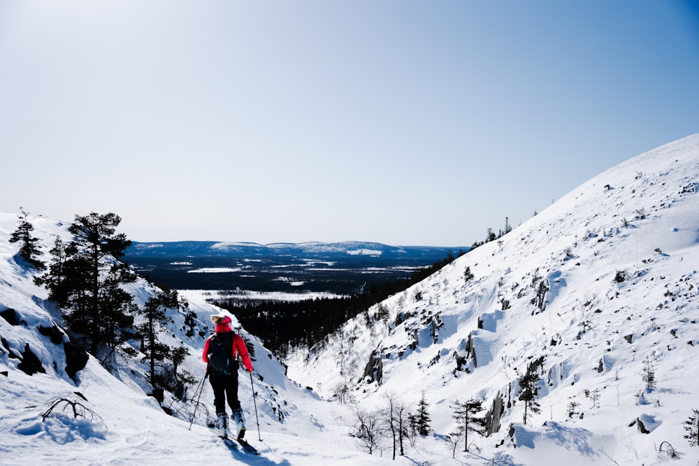 a man riding skis down the side of a snow covered slope