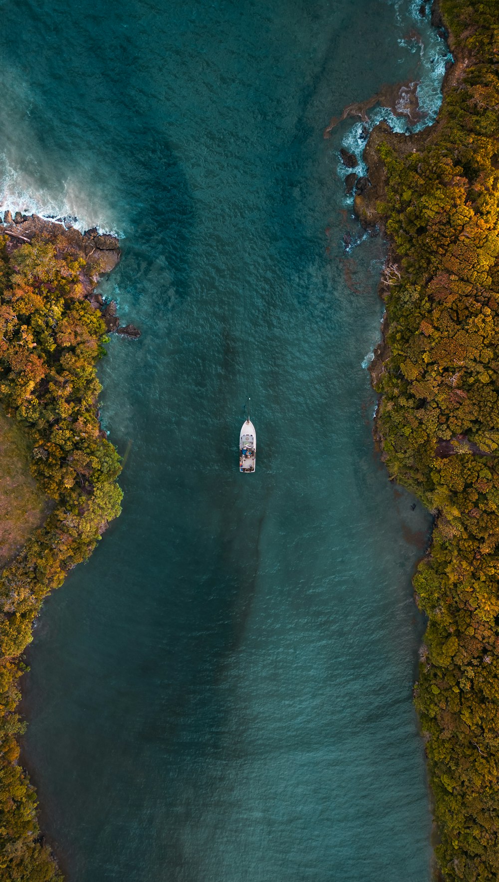 an aerial view of a boat in a body of water